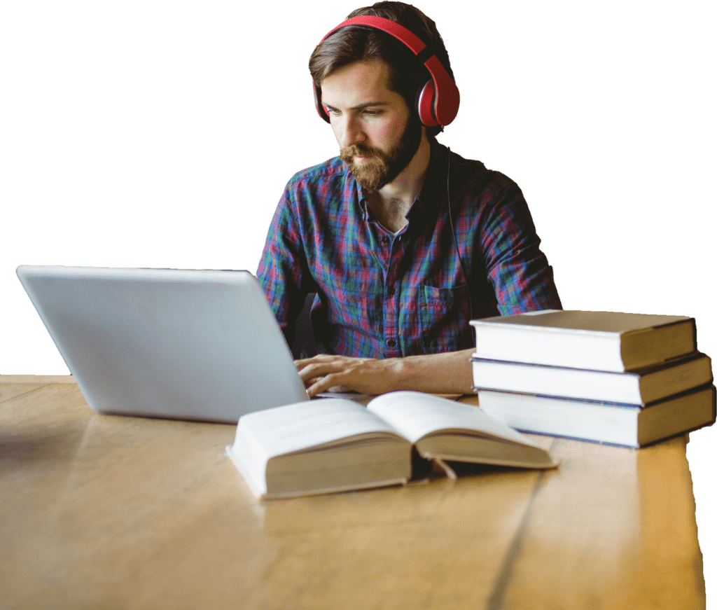 Adult male at a computer with a stack of books