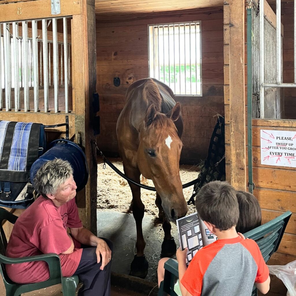 young children reading to a horse